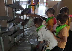 czwórka dzieci obsewruje przelwającą się wodę