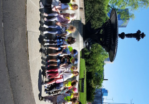 Dzieci z nauczycielką na tle fontanny