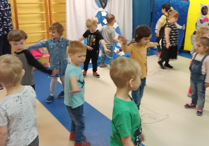 dzieci z rozłożonymi na boki rękami wykonują taneczne ruchy