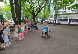 dzieci obserwują taniec kobiety na wózku