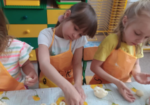 trzy dziewczynki przy stoliku formułują kluski śląskie