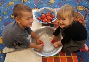 Chłopiec i dziewczynka myją jabłka