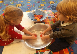 Chłopiec i dziewczynka myją jabłka