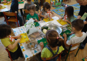 Dzieci kroją warzywa i owoce
