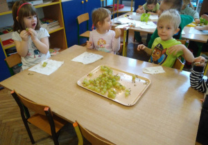 Dzieci jedzą zielony winogron
