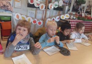 Dzieci jedzą naleśniki przy stole
