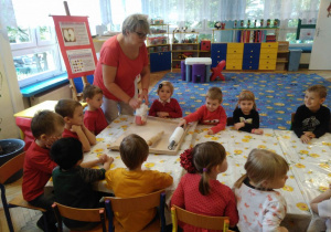 Dzieci ubrane na czerwono siedzą przy stolikach