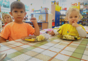 Dwóch chłopców przy stoliku jedzą obiad