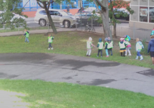 Dzieci zbierają śmieci na placu zabaw