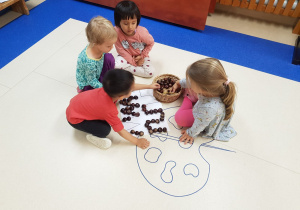 dzieci układają wzory z kasztanów