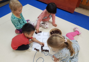 dzieci układają wzory z kasztanów