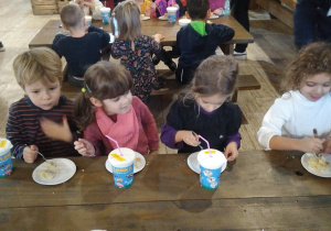 dzieci przy stoliku jedzą szarlotkę