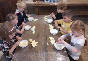 dzieci przy stoliku kroją jabłka