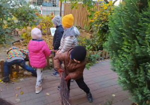 dzieci w ogrodzie robią porządki