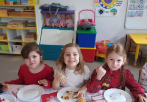 trzy dziewczynki siedza przy stoliku