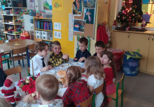 dzieci przy stoliku jedzą