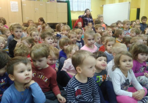 Dzieci siedzą na sali gimnastycznej