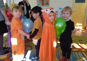 czwórka dzieci tańcząca z balonami