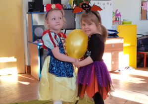 dwie dziewczynki tańczace z balonem